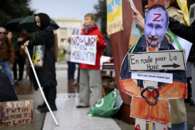 Plakat przedstawiający zdjęcie prezydenta Rosji Władimira Putina i wskazujący na kierunek do Hagi
